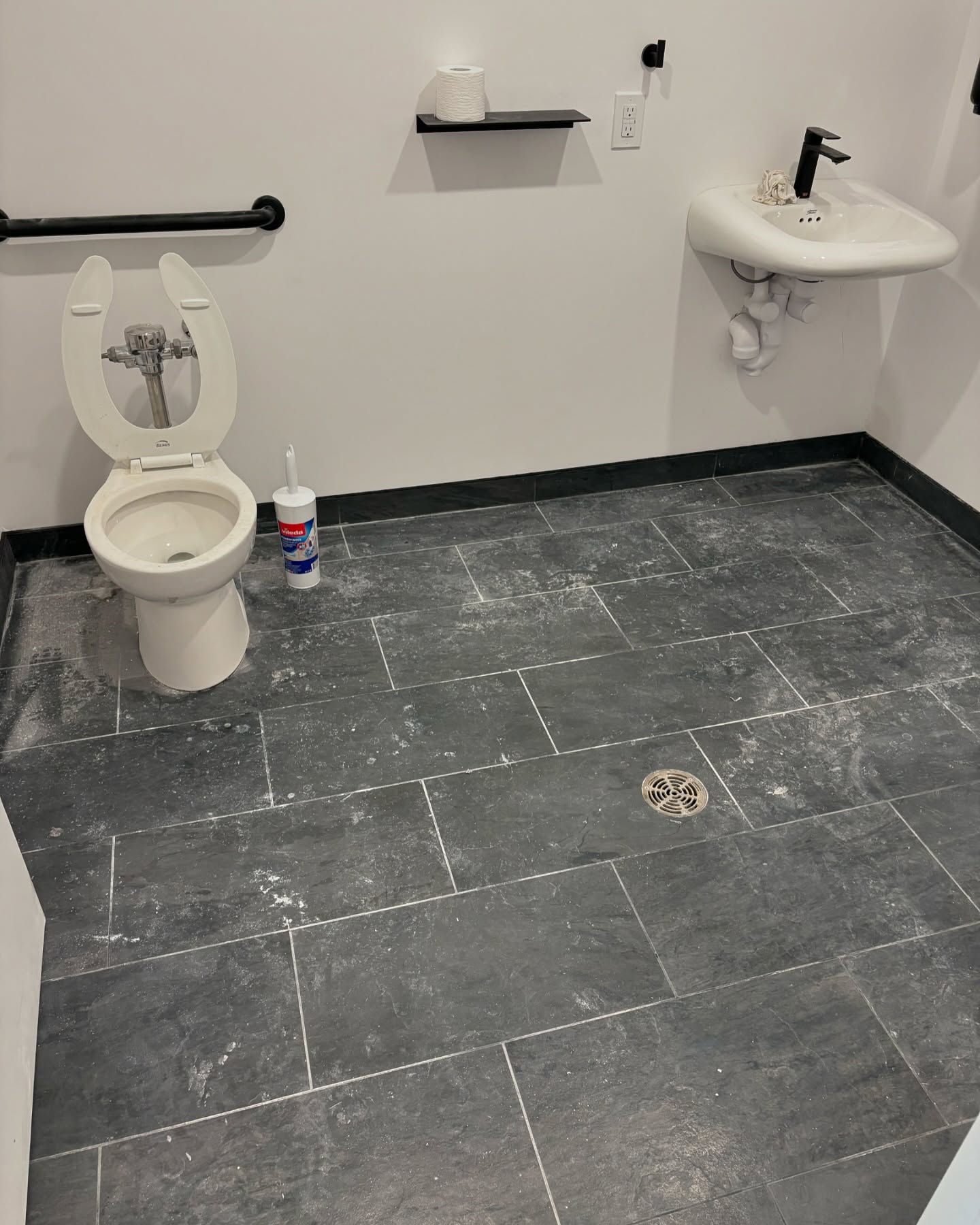 A bathroom floor covered in post-construction dust.